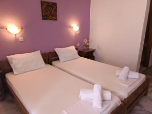 two beds in a room with towels on them at Haras rooms in Nikiana