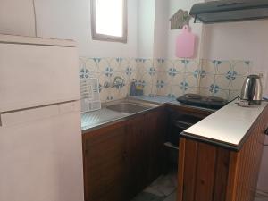 a small kitchen with a sink and a stove at Haras rooms in Nikiana +22 photos