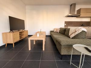 a living room with a couch and a table at Sea Road Perpignan in Perpignan