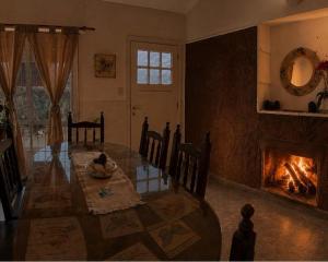 a living room with a table and a fireplace at cabaña EL CHALECITO DE ANA in Villa del Dique