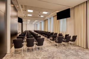 a conference room with a row of chairs and a screen at Radisson Hotel Brussels Centre Midi in Brussels