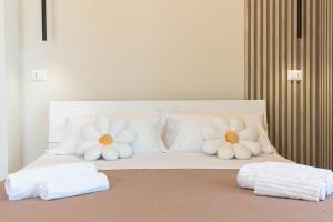 two white pillows on a bed with towels on it at VJ Apartment in Giardini Naxos
