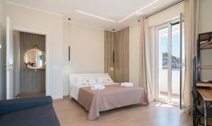 a white bedroom with a bed and a couch at VJ Apartment in Giardini Naxos