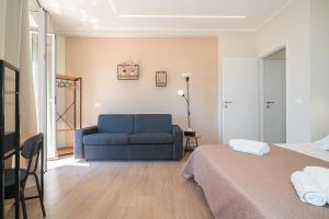 a bedroom with a blue couch and a bed at VJ Apartment in Giardini Naxos