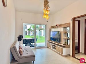 a living room with a couch and a television at Boas Vistas - Canoa Quebrada in Canoa Quebrada