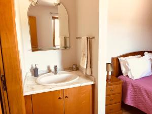 a bathroom with a sink and a mirror and a bed at Casa da Lage - T1 - Piscina privada - BBQ - Vistas rio - "Gerês" in Geres +33 photos
