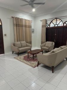a living room with two couches and a coffee table at Jiddah Homestay in Tumpat