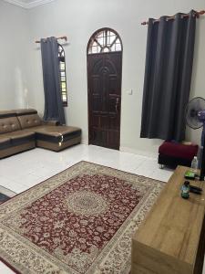 a living room with a brown door and a rug at Jiddah Homestay in Tumpat