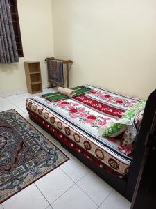 a bedroom with two beds and two rugs on the floor at Jiddah Homestay in Tumpat