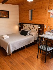 a bedroom with a bed and a table with a chair at Monoambiente D'Charruas in Chajarí