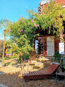 a garden with a bench and a tree with flowers at Monoambiente D'Charruas in Chajarí +1 photo