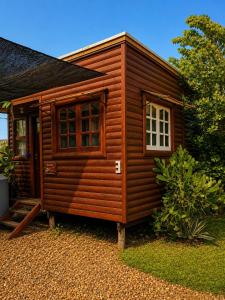 a wooden cabin with a window on a gravel yard at Monoambiente D'Charruas in Chajarí