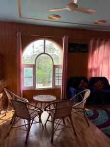 a living room with a table and chairs and a window at Giggle in Srinagar +11 photos