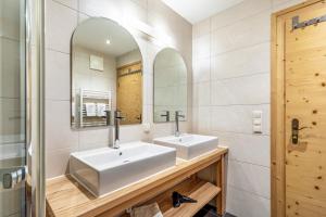a bathroom with two sinks and a mirror at Appartements Stockinger B4 in Grossarl +29 photos