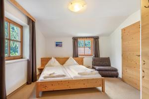 a small bedroom with a bed and a chair at Appartements Stockinger B4 in Grossarl