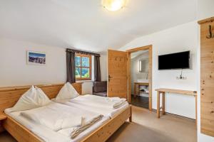 a bedroom with a bed and a tv on a wall at Appartements Stockinger B4 in Grossarl