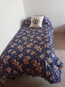 a bed with a blue comforter with a pillow on it at Los patos in Capilla del Monte +4 photos