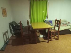 a table and chairs in a room with a cat under it at Los patos in Capilla del Monte