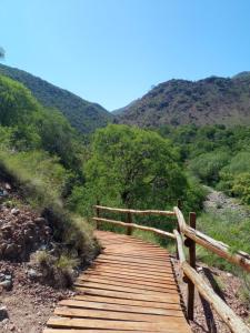 a wooden boardwalk on a hill with mountains in the background at Los patos in Capilla del Monte