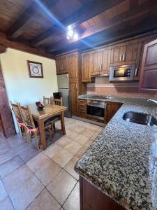 a kitchen with a table and a dining room at Gestiona2R - Casa en Colombres centro in Colombres