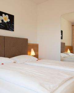 a large white bed in a room with two beds at Das Filipinum in Merano +38 photos