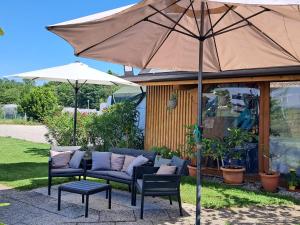 a patio with a couch and an umbrella at B&B DA ROBERTINO in Tricesimo