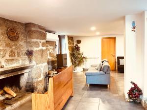 a living room with a stone fireplace and a couch at Casa da Lage - T1 - Piscina privada - BBQ - Vistas rio - "Gerês" in Geres