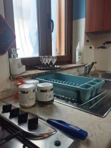 a kitchen counter with pots and pans on a drying rack at La casetta del pescatore - Le case di Bettina in Torrenova +20 photos