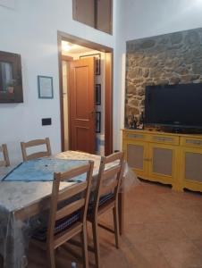 a dining room with a table and a television at La casetta del pescatore - Le case di Bettina in Torrenova
