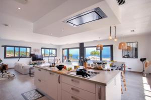 an open kitchen and living room with a lot of windows at Villa Bianca in LʼÎle-Rousse +39 photos