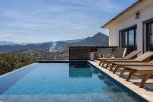 a swimming pool with chairs and a house at Villa Bianca in LʼÎle-Rousse