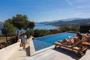 two women laying on lounge chairs next to a swimming pool at Villa Bianca in LʼÎle-Rousse