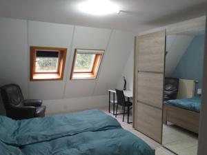 a bedroom with a bed and a chair and a desk at logies 'Raapbreuk' in Herentals
