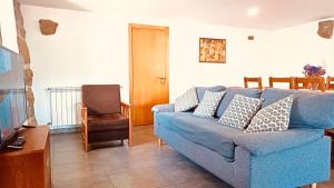 a living room with a blue couch and a chair at Casa da Lage - T1 - Piscina privada - BBQ - Vistas rio - "Gerês" in Geres
