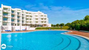 a swimming pool in front of a hotel at Prainha Clube in Alvor