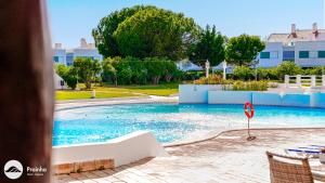 a swimming pool with a no swimming sign in it at Prainha Clube in Alvor