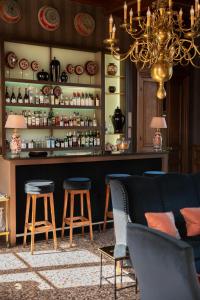 a bar with a couch and stools in a room at Château Sainte Sabine in Sainte-Sabine