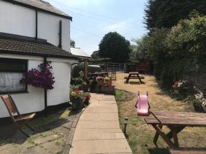 a house with a bench and a picnic table at Brewery Lodge in Blakeney +2 photos