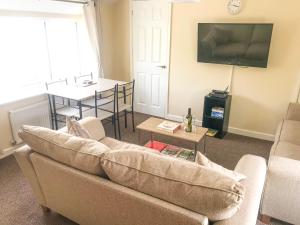 a living room with a couch and a table at Brewery Lodge in Blakeney