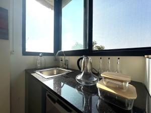 a kitchen counter with two wine glasses and a sink at Shakti, Abdelli guesthouse in Batroûn +11 photos