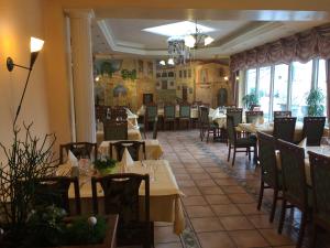 a dining room with tables and chairs in a restaurant at Hotel-Restaurant La Fontana in Sankt Ingbert