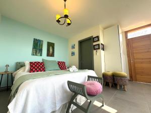 a bedroom with a bed and a chair in it at Shakti, Abdelli guesthouse in Batroûn