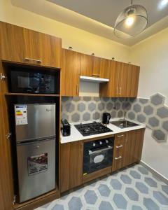 a kitchen with a stove and a refrigerator at Havenstay in Yaoundé