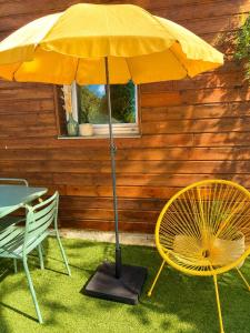 a yellow umbrella sitting next to a table and chairs at Ker Sonia in Angers +3 photos