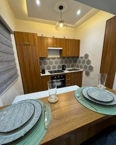 a kitchen with a wooden table with plates on it at Havenstay in Yaoundé +12 photos