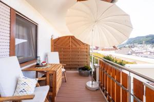 a balcony with a table and an umbrella at Hofquartier in Kappelrodeck