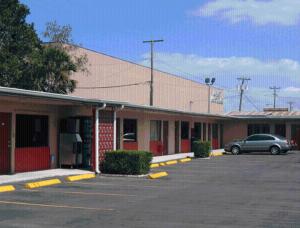 a car parked in a parking lot outside of a motel at Plaza Travel Inn in Clewiston