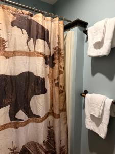 a shower curtain with a black bear on it in a bathroom at Allegory Inn in Twin Mountain +124 photos