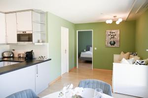a kitchen and living room with green walls at Cozy Swiss Apartment - City & Mountain view in Interlaken +12 photos