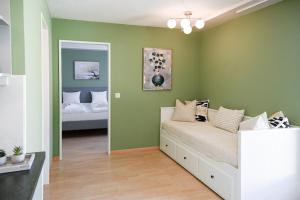 a bedroom with a bed in a room with green walls at Cozy Swiss Apartment - City & Mountain view in Interlaken